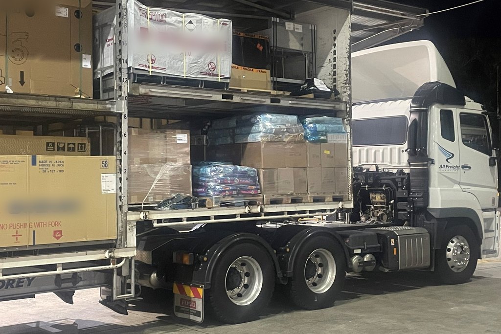 An All Freight Carrying prime mover and double-deck trailer loaded with pallets and cartons for overnight linehaul